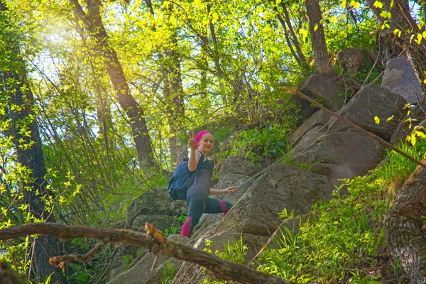 A menina se levanta através de um belo penhasco florestado, muita vegetação e falésias . — Fotografia de Stock