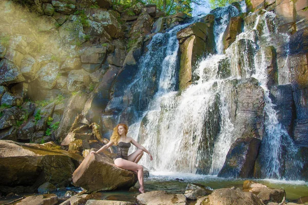 Menina bonita posando em uma cachoeira alta, menina ruiva absolutamente deserta em uma cachoeira . — Fotografia de Stock