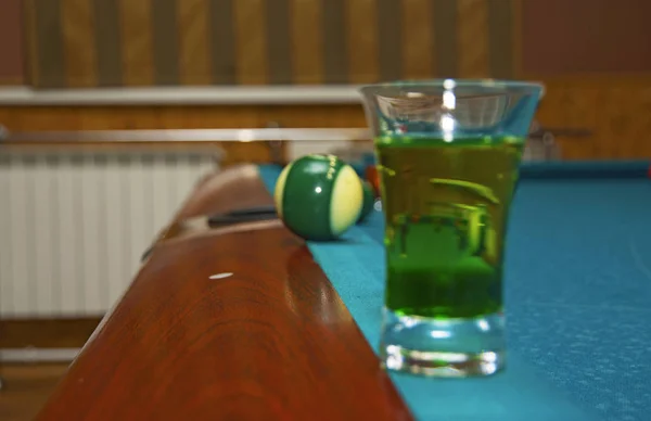 Sobre una mesa de billar con copas de color de alcohol . — Foto de Stock