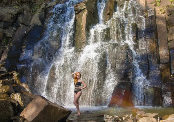 Bella ragazza in posa in un'alta cascata, assolutamente deserta rossa ragazza in una cascata . — Foto Stock