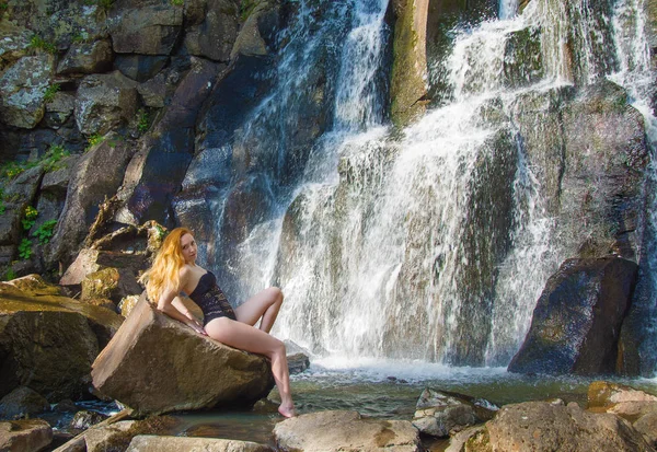 Hermosa chica posando en una alta cascada, chica pelirroja absolutamente desierta en una cascada . — Foto de Stock