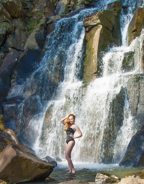 Menina bonita posando em uma cachoeira alta, menina ruiva absolutamente deserta em uma cachoeira . — Fotografia de Stock