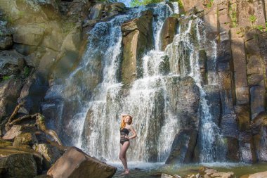 yüksek bir şelale içinde bir şelale kesinlikle ıssız Kızıl saçlı kız poz güzel kız.