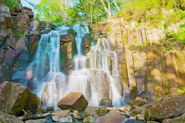 güzel orman şelale. Taşlı yamaçta fırtınalı orman şelale çalışır.