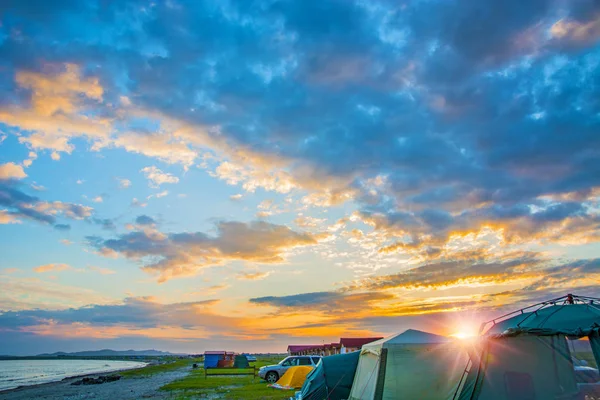 Jasny czerwony zachód słońca na plaży, istnieje kilka namiotów. obóz turystyczny — Zdjęcie stockowe