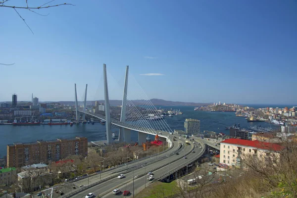 Bron över viken, i hamnstaden. solig dag och blomstrande grönska — Stockfoto