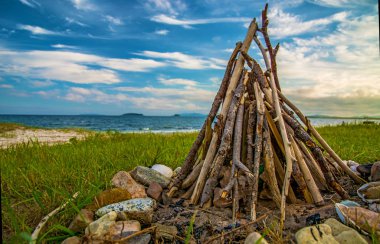 ahşap deniz kenarında plajda şenlik ateşi. bir şekilde dekore edilmiş taşlar.