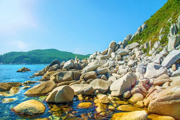 güzel bir plaj birçok yüksek taşları tahrip kayalar, ağaçlar büyümek.