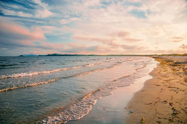 parlak altın günbatımı sahilde, kum, dalgalar kabuklar.