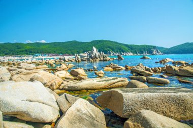 güzel bir plaj birçok yüksek taşları tahrip kayalar, ağaçlar büyümek.