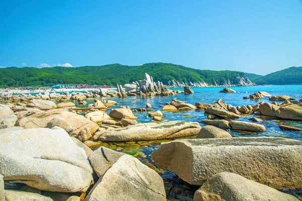 güzel bir plaj birçok yüksek taşları tahrip kayalar, ağaçlar büyümek.