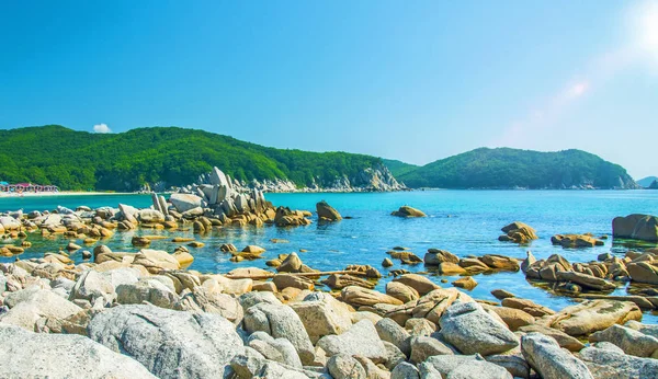 güzel bir plaj birçok yüksek taşları tahrip kayalar, ağaçlar büyümek.