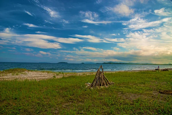 Holzfeuer am Strand in der Nähe des Meeres. rund um die verzierten Steine. — Stockfoto