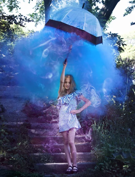 Chica joven con paraguas en la mano, en las escaleras, que se encuentra con el humo brillante, azul . — Foto de Stock