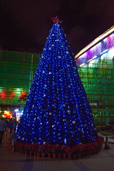 Árbol de Navidad decorado con guirnaldas y juguetes en el Trópico, la noche Sanya ciudad en el nuevo año . —  Fotos de Stock