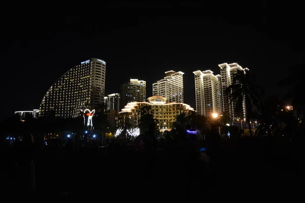 Cidade noturna Sanya todas as luzes, luzes brilhantes adornam o edifício. os trópicos . — Fotografia de Stock