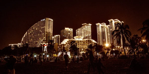 Noche ciudad Sanya todas las luces, luces brillantes adornan el edificio. los trópicos . — Foto de Stock