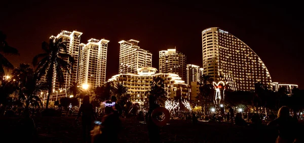 Noche ciudad Sanya todas las luces, luces brillantes adornan el edificio. los trópicos . — Foto de Stock