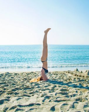 genç, güzel, Kızıl saçlı kız sahilde yoga uygulamaları.