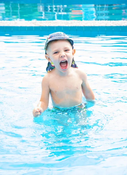 小さな男の子が泳ぐと、ジャンプ サークル、屋外スイミング プールでは、プールで元気な子, — ストック写真