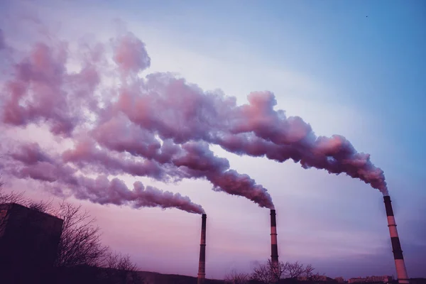 Muitos tubos grandes dos quais vai fumaça suja, gases de escape e pastores, acima da cidade , — Fotografia de Stock