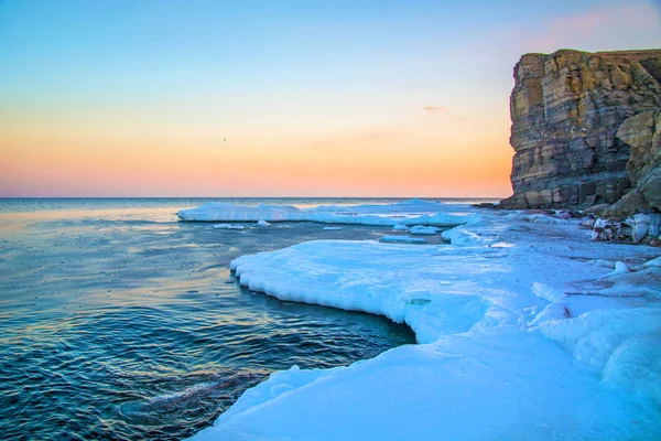 Yüksek kayalıklarla tüm içinde buz denizi ne dökülür. Buzun içinde kaya gün batımında. gelen giden güzel bir manzara güneş.
