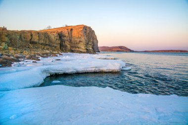 Yüksek kayalıklarla tüm içinde buz denizi ne dökülür. Buzun içinde kaya gün batımında. gelen giden güzel bir manzara güneş.