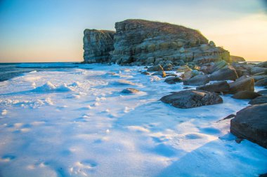 Yüksek kayalıklarla tüm içinde buz denizi ne dökülür. Buzun içinde kaya gün batımında. gelen giden güzel bir manzara güneş.