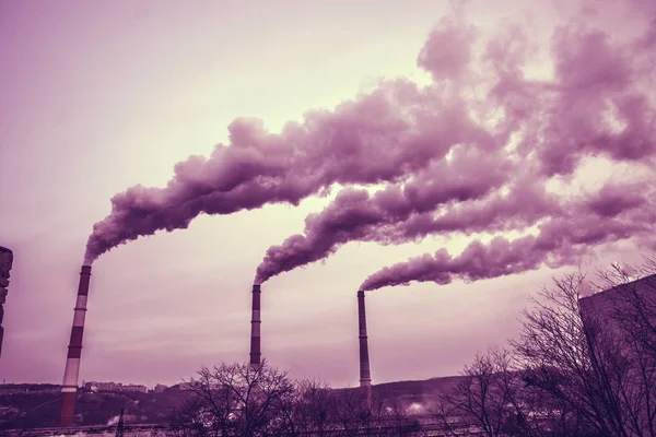 Muitos tubos grandes dos quais vai fumaça suja, gases de escape e pastores, acima da cidade , — Fotografia de Stock