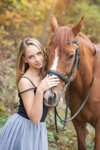 Mladá, blond dívka pózuje s koněm, krásná dívka a silné koně. — Stock fotografie