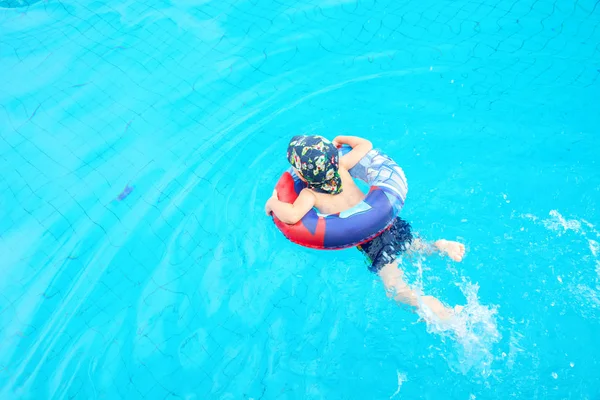 Jongetje zwemt, vrolijk kind springen in het zwembad in de cirkel, openlucht zwembad, — Stockfoto