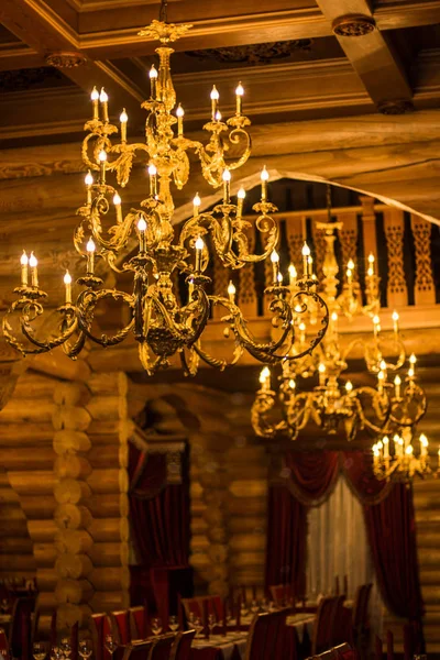 Grandes lámparas de araña hermosas, de color oro, altas lámparas de araña hermosas que cuelgan del techo. Decoración del ornamento . — Foto de Stock
