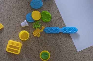 Moldes de juguete para usar con plastilina de color azul amarillo y verde. Juguetes de nios en el suelo con plastilina verde