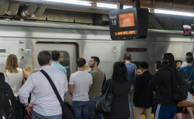 Long Island demiryolu tren Penn İstasyonu, Manhattan. İnsanlar uzun Plajı'na parça duyuru için platform üzerinde bekleyin 