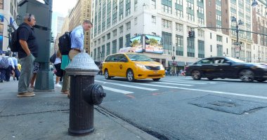 Midtown kavşak düşük açılı görünüş yangın hidrant geçmiş arasında yoğun trafik. Sabah gidip yaya geçidi Emanet için kırmızı ışıkta beklemek