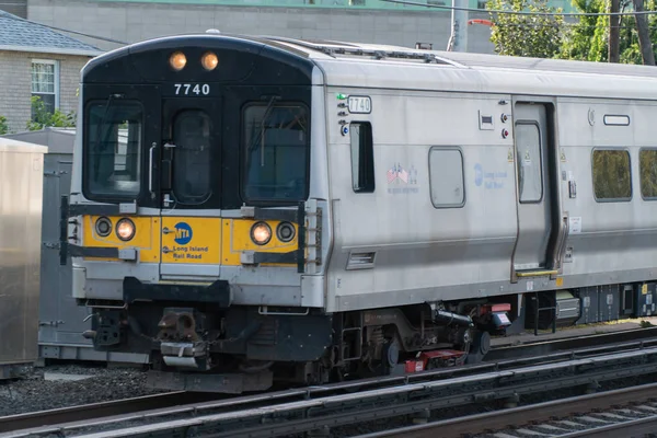 Long Island Railroad trem carro fechar viagem na pista para a estação. Motor locomotivo de potência elétrica — Fotografia de Stock