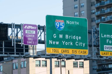 Highway signs direct and inform drivers travel into Manhattan New York City via George Washington Bridge to pay dollar toll fee for crossing clipart