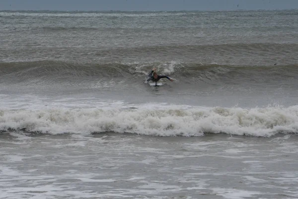 Mannelijke surfer ritten golven van offshore orkaan van het Atlantische Oceaan in strand voor extreme sport activiteit — Stockfoto