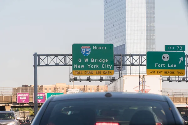 Highway signs overhead road direction to Manhattan over George Washington Bridge through toll plaza collection fee — Stock Photo, Image