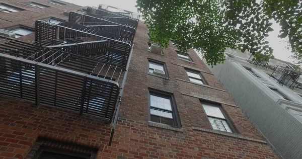 Vue verticale droite vers le haut de l'immeuble typique en brique générique de New York avec sortie de secours sur les fenêtres et la façade . — Photo