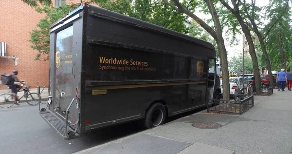 UPS Worldwide Services - United Parcel entrega de paquetes y transporte de camiones de la compañía en la calle de la ciudad — Foto de Stock