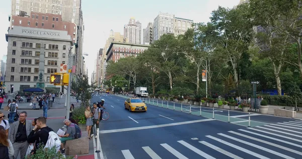 Ampia vista panoramica fuori dal parco di New York dell'incrocio trafficato di Manhattan di auto che passano e persone che attraversano la strada in un passaggio pedonale di sicurezza in una giornata estiva — Foto Stock