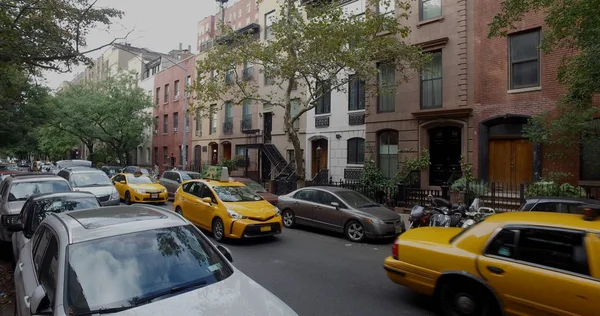 マンション黄色いタクシーで典型的な一般的なニューヨーク市ブロックの外部の打撃を広い視野トラフィックを運転台し、通りの側に並ぶ車を駐車. — ストック写真