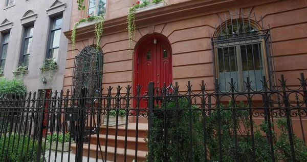 Generic urban city apartment building door exterior with steel fence and bars on first floor windows for street security. Outside establishing shot. — Stock Photo, Image