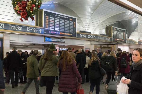 Long Island Railroad passants passants passent sous grand panneau pour les annonces de la voie ferrée quittant NYC voyage à la maison pendant les heures de pointe — Photo