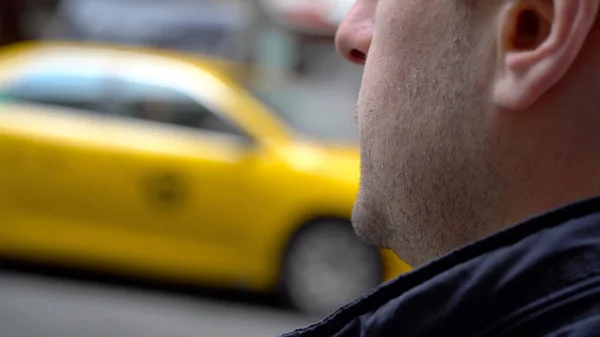 白天在纽约市等待黄色出租车的年轻人的肩膀上. — 图库照片