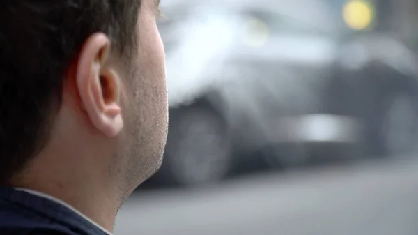 在肩膀上的视角, 年轻的城市嬉皮士男子吸烟在城市街道外的电子蒸汽。呼出由调味油产生的蒸发烟雾. — 图库照片