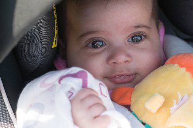 Araba koltuğu gülümseyen içinde şirin genç mutlu bebek bebek. Sulu göz yaşartıcı göz ve diş çıkarma ağzından salyalar
