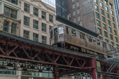 Chicago L treni gündüz vakti şehir merkezindeki apartmanların önünde çekim yapıyor. Lüks pahalı emlak konumu