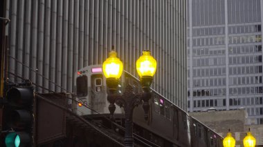 Chicago L treni gündüz vakti şehir merkezindeki ofis binalarının önünde çekim yapıyor. Şirket karargahı için lüks ve pahalı bir yer.